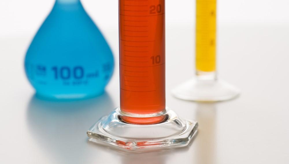 Kuva, jossa kaksi mittalasia ja Erlenmeyer-pullo, joissa kaikissa värikkäitä liuoksia